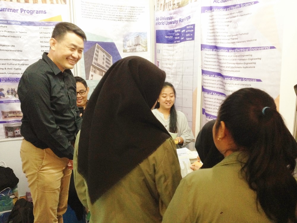 圖說：室內設計學系施勝誠老師(右三)在教育展現場解說，與印尼學生互動熱絡。